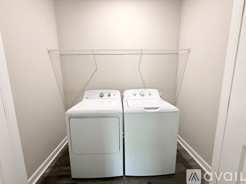 Two white front loading washing machines in a laundry room.