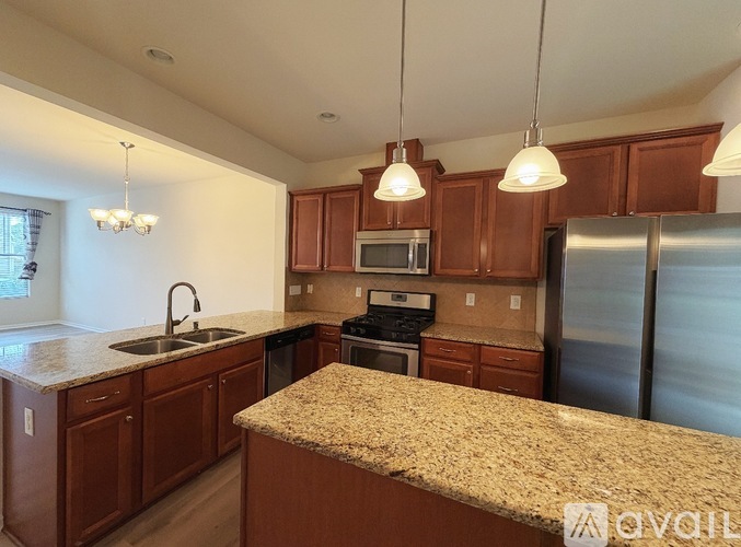A kitchen with wooden cabinets and granite countertops.