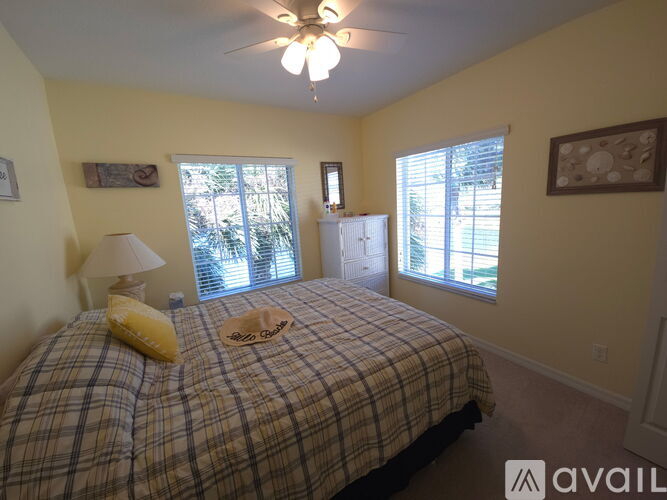 A bedroom with a bed, a ceiling fan, and a window.