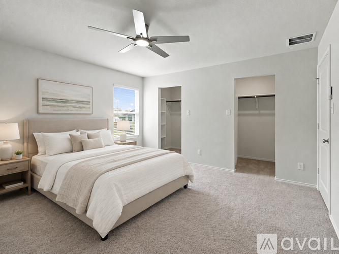 A bedroom with a large bed and a ceiling fan.