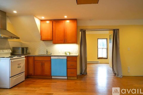 A kitchen with wooden cabinets and a white dishwasher.