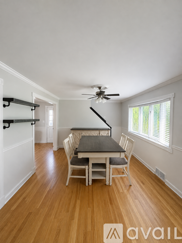 A dining room with a table and chairs.