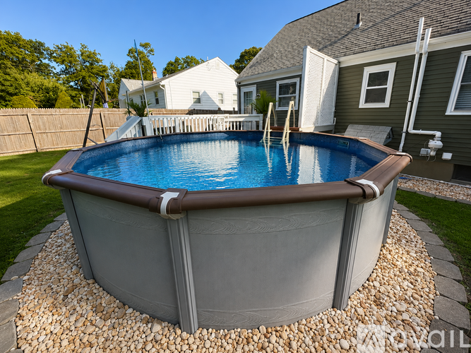 A round above ground pool with a brown border and a brown skirt.
