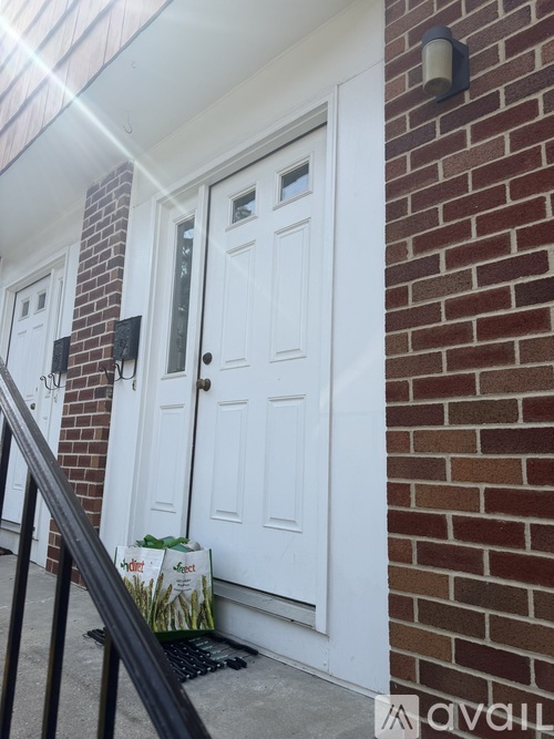 A white door is on a brick house.