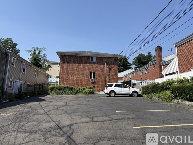 A parking lot with a car parked and a building in the background.