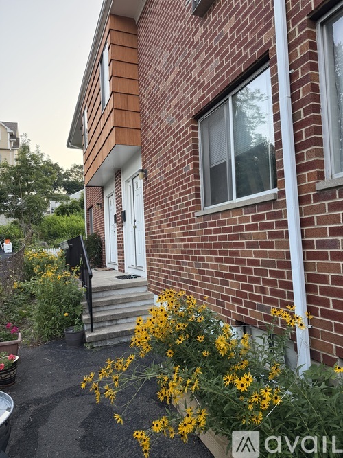 A house with a white door and windows with a flower bed in front.