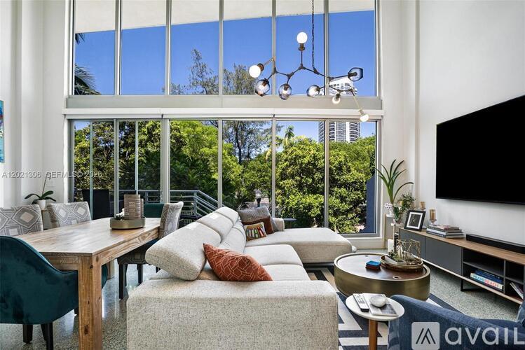 A modern living room with a large window overlooking a cityscape.