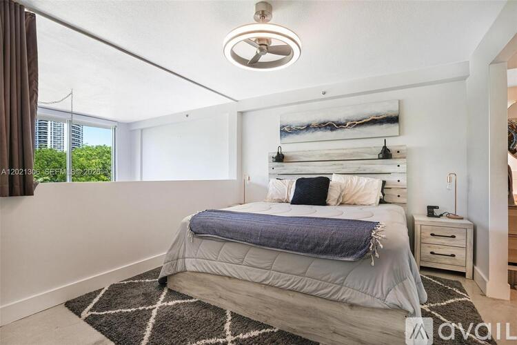A bedroom with a large bed and a ceiling fan.