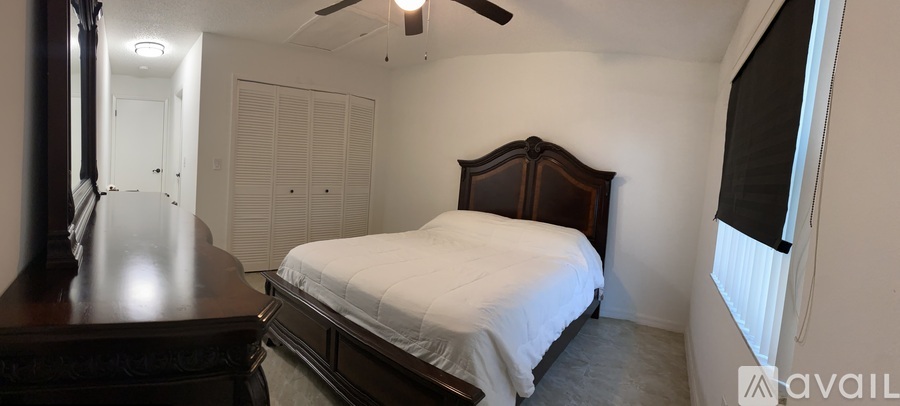 A bedroom with a bed, dresser, and mirror.
