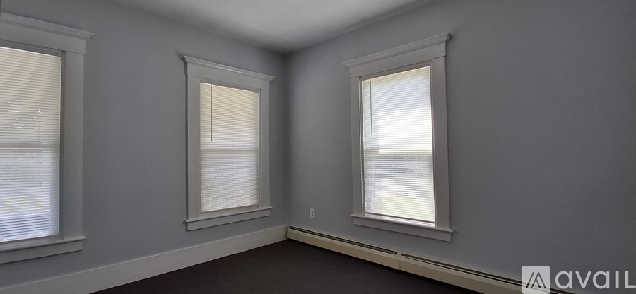 A room with two windows and a sign that says "available".