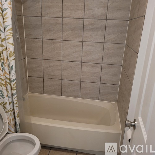A bathroom with a tiled shower area and a toilet.