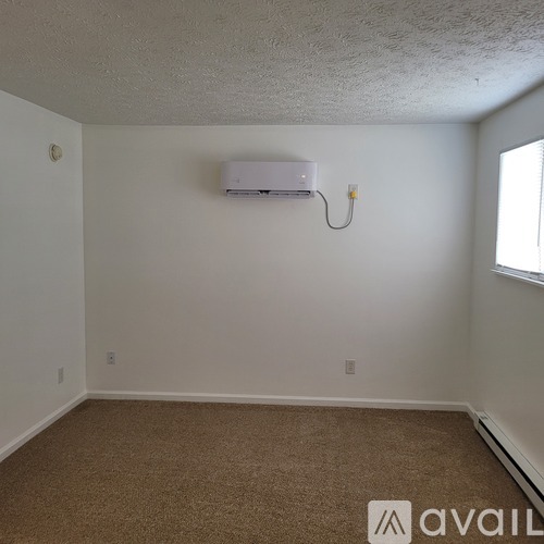 A room with a carpeted floor and a window.
