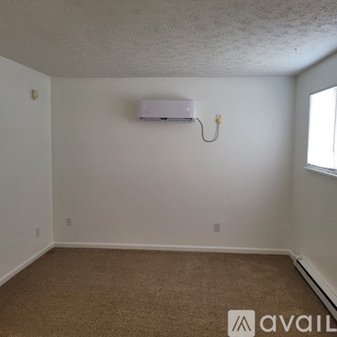 A room with a carpeted floor and a window.