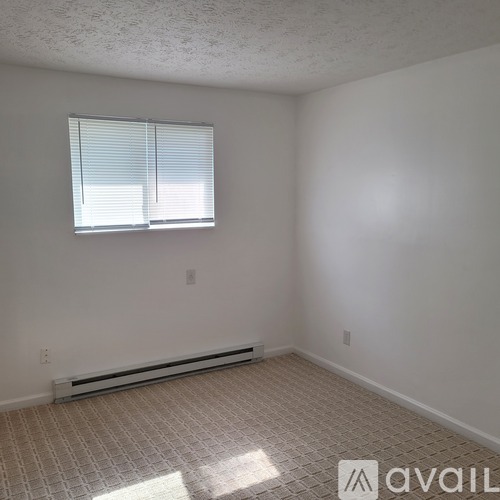 A room with a window and a radiator on the floor.