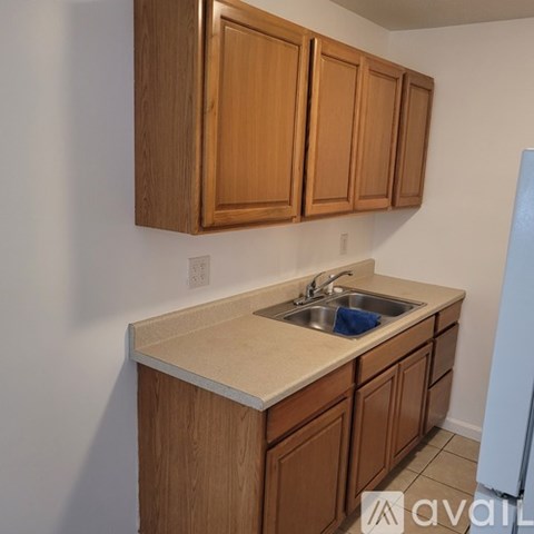 A kitchen with wooden cabinets and a white fridge.