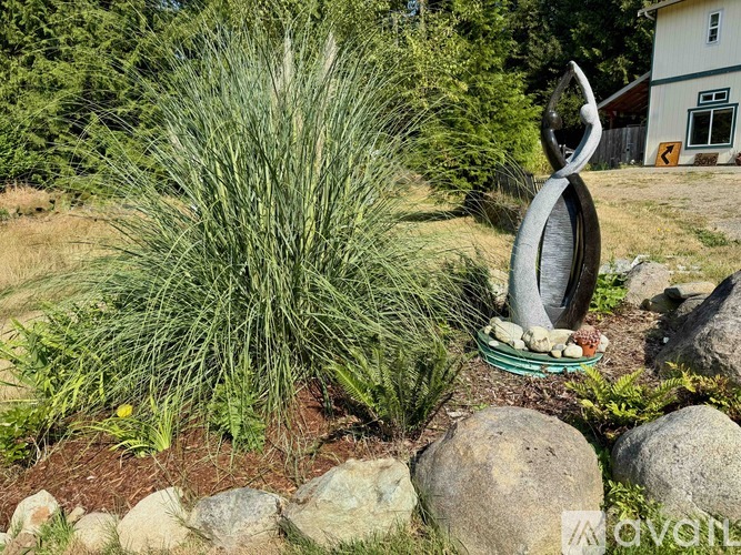 A garden with a large sculpture and a grassy area.