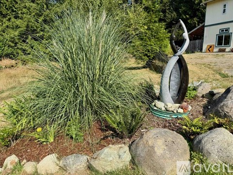 A garden with a large sculpture and a grassy area.