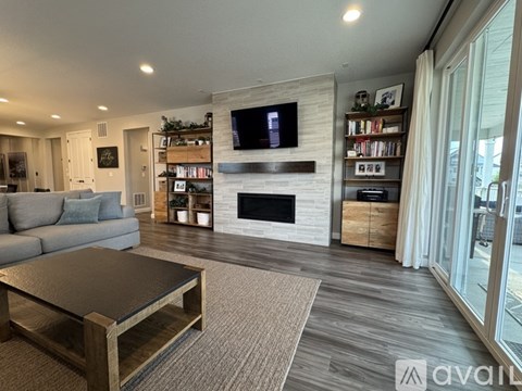 A living room with a fireplace and a television on the wall.