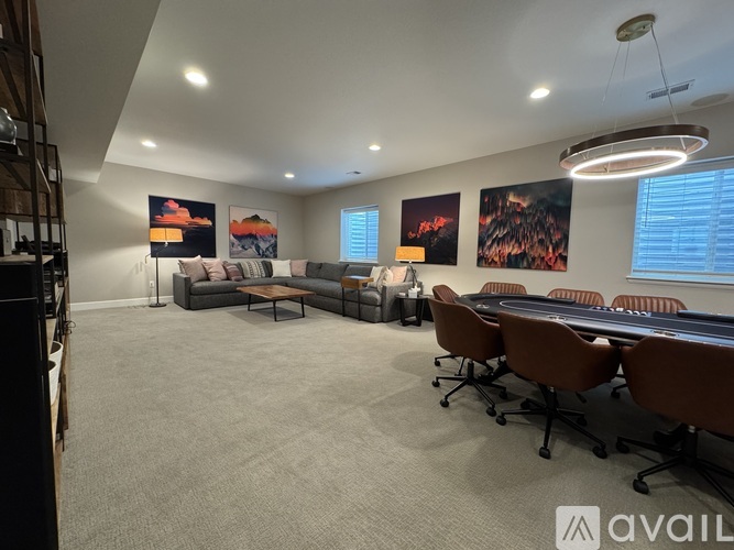 A conference room with a long table and chairs, and paintings on the wall.