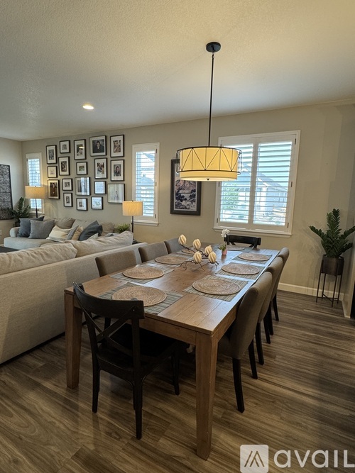 A dining room with a wooden table set for a meal.