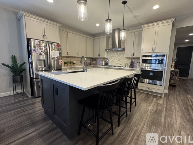 A modern kitchen with a large island and stainless steel appliances.