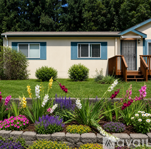 A house with a blue door and a flower bed in front.