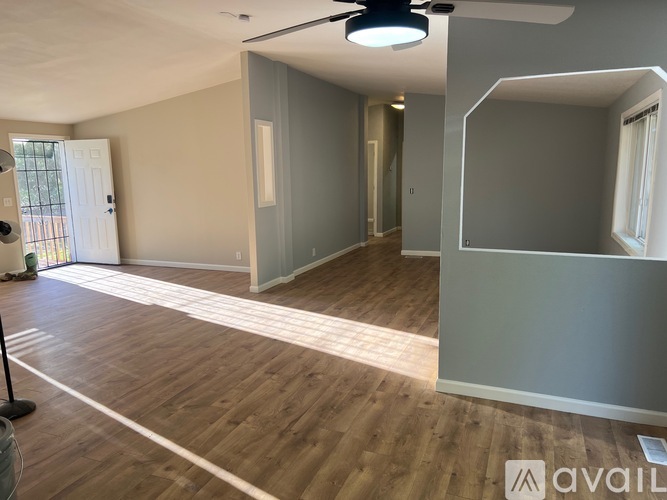 A room with wooden flooring and a ceiling fan.