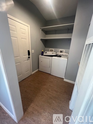 A small kitchen with white appliances and a white door.