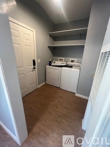 A small kitchen with white appliances and a white door.
