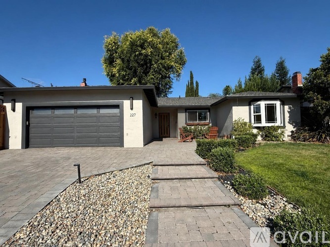 A house with a driveway and a garage door numbered 227.