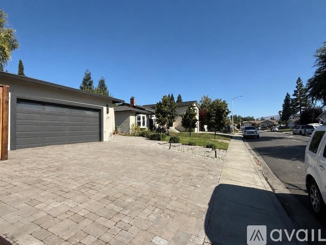 A residential street with a white car parked on the side.