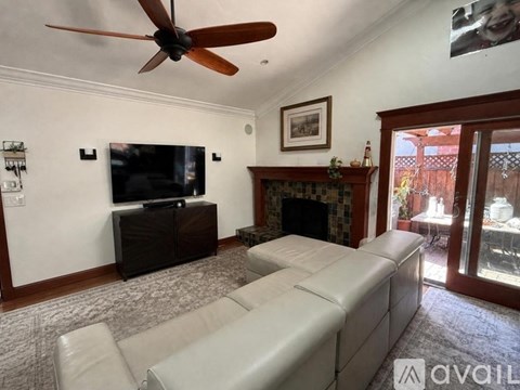 A living room with a white couch and a ceiling fan.