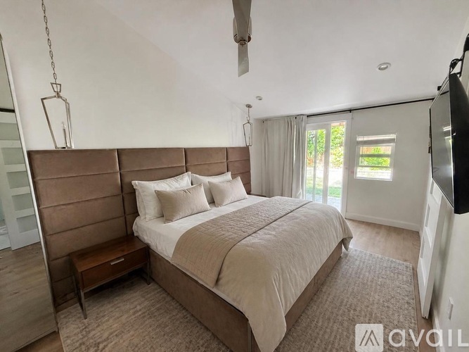 A bedroom with a large bed and a ceiling fan.