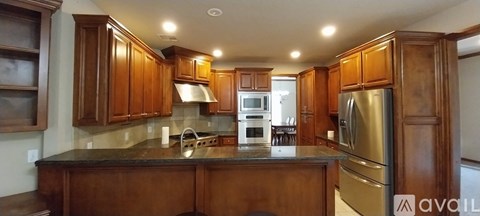 A kitchen with wooden cabinets and a black countertop.