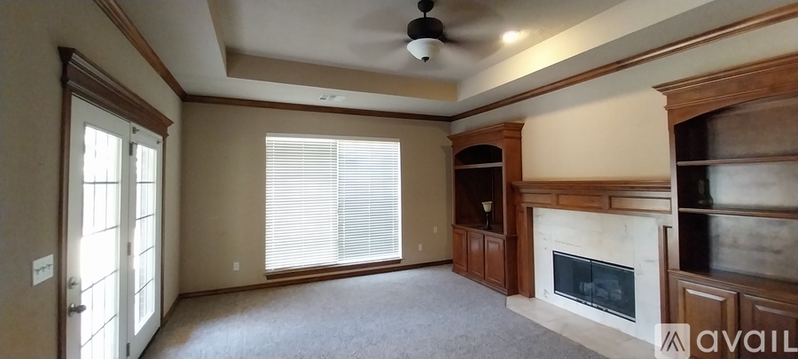 A living room with a fireplace and a ceiling fan.