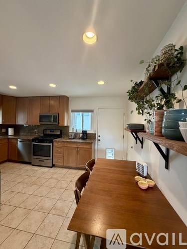 A kitchen with a wooden table and chairs in the foreground.