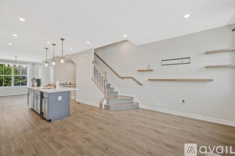 A spacious living room with a staircase leading to the upper floor.