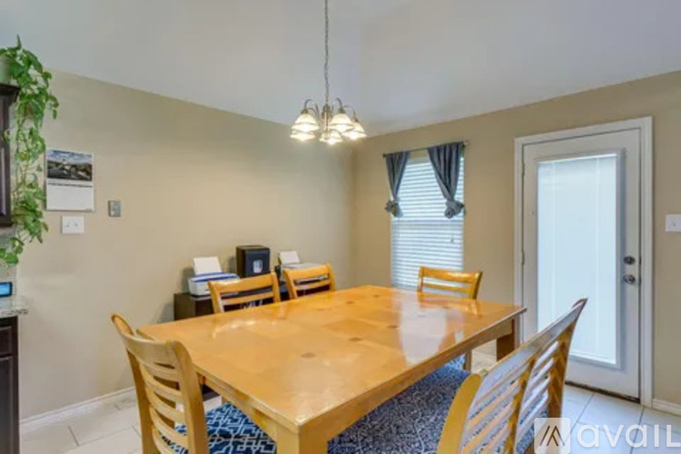 A dining room with a wooden table and chairs.