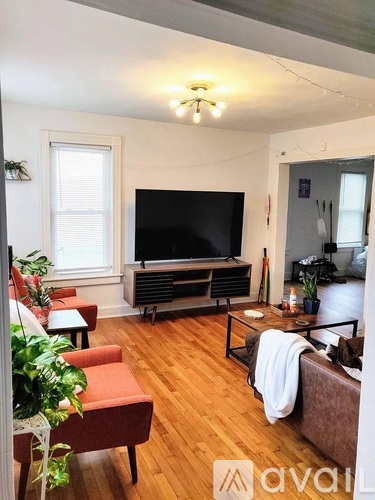 A living room with a television, a couch, and a chair.