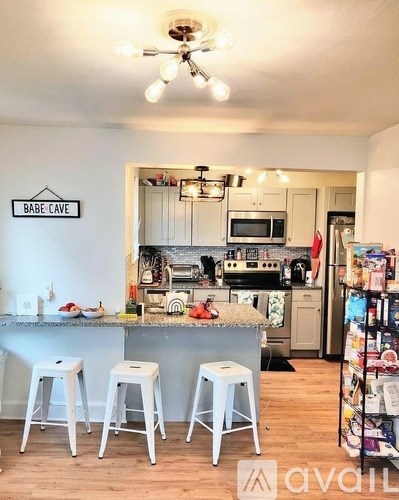 A kitchen with a bar area and a sign that says "BABE CAVE".