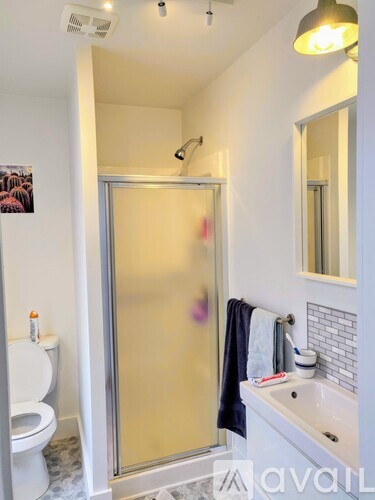 A bathroom with a toilet, sink, and shower.