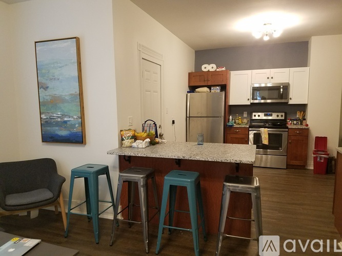 A kitchen with a bar area and a painting on the wall.