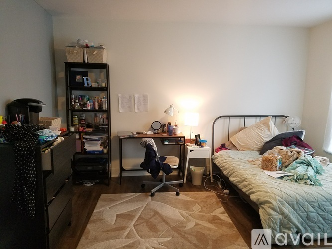 A bedroom with a bed, desk, and chair.