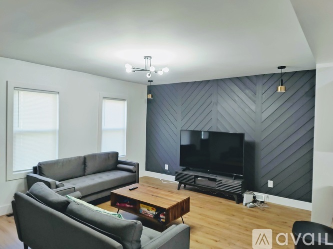 A living room with a grey couch, a coffee table, and a television.