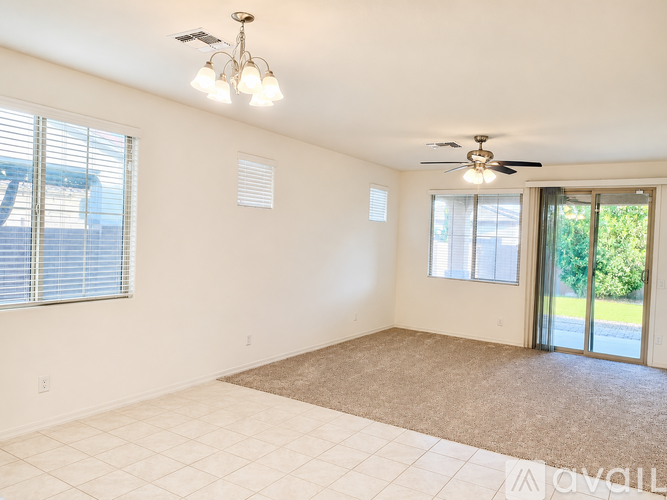 A spacious room with a ceiling fan and sliding glass doors.