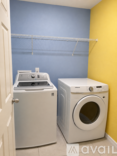 A white dryer and washing machine in a laundry room.