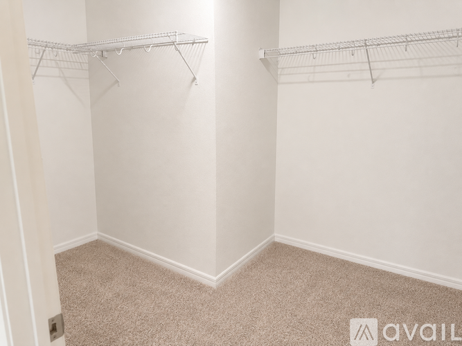 Empty room with white walls and carpeted floor.