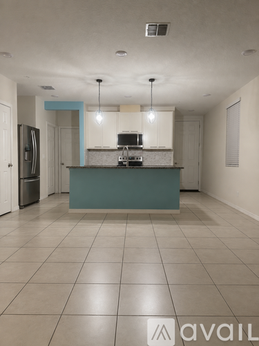A kitchen with a blue island and white cabinets.