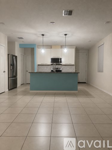 A kitchen with a blue island and white cabinets.