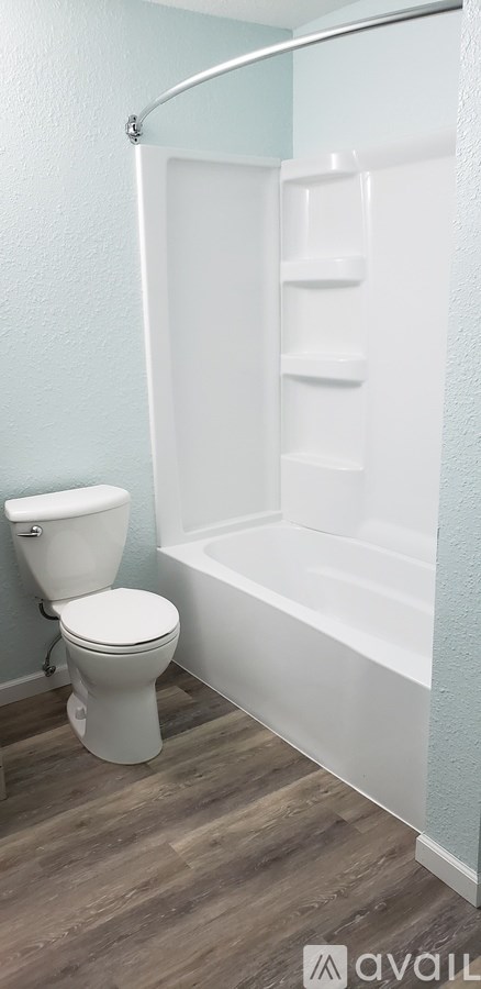 A white toilet sits next to a white bathtub in a bathroom.